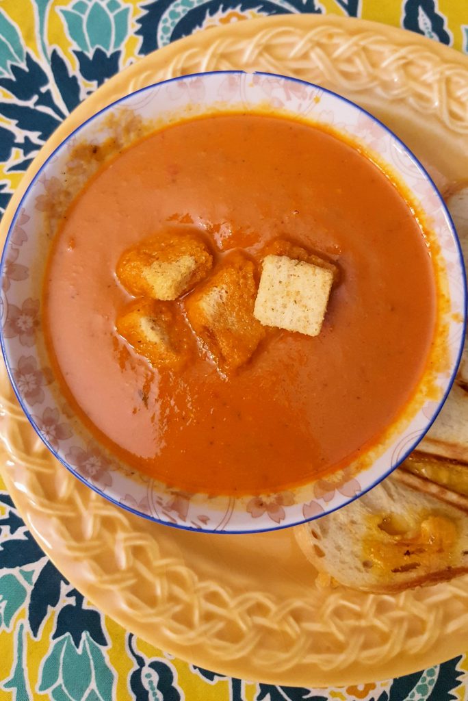 bowl of cream of tomato soup topped with croutons
