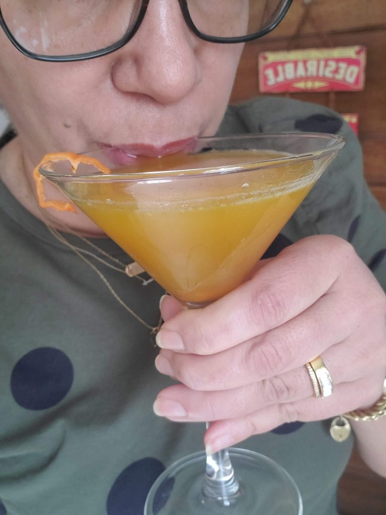 woman sipping martini cocktail