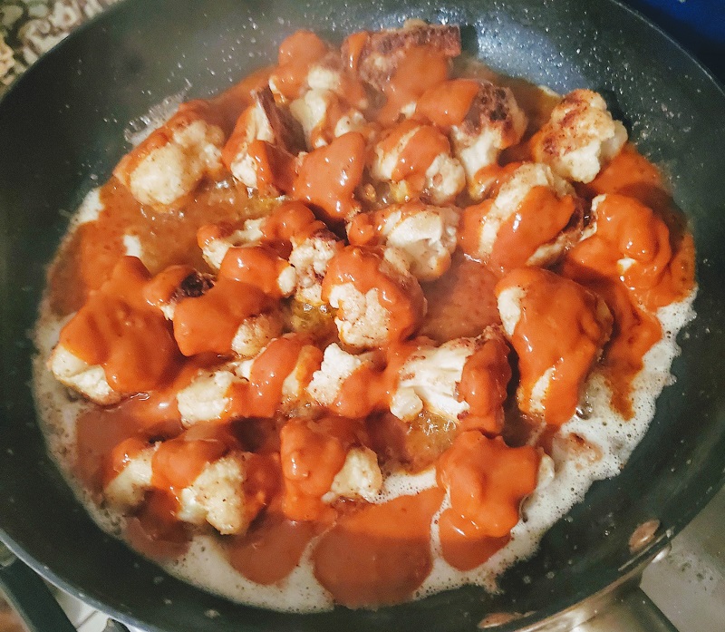 cauliflower in pan doused with hot sauce