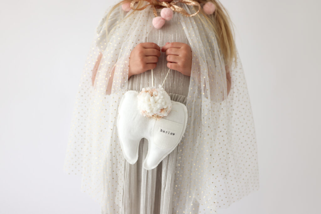 little girl holding a keepsake stuffed fairy tooth pillow